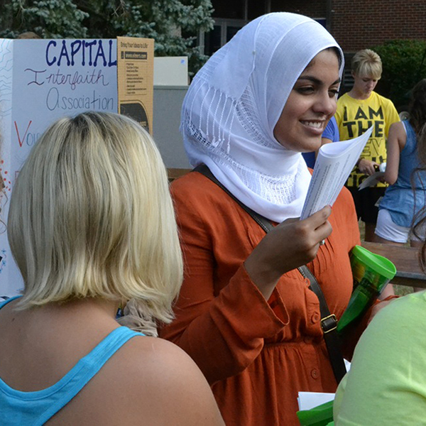 An international student provides information at a booth during 热博体育's welcome weekend